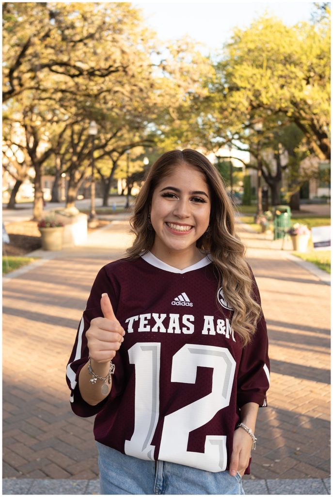 Classic smiling photo with a thumbs up (gig'em).