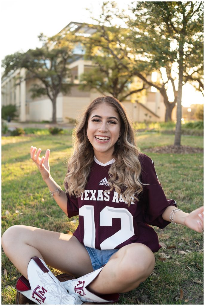 Future Aggie sitting down smiling at the camera. The photo is a candid moment with her arms slightly moving. 