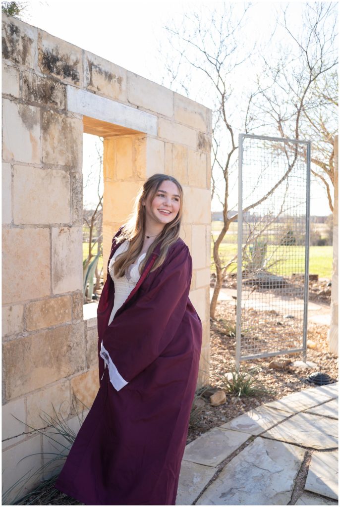 Senior in her A&M Consolidated graduation gown. She is twirling around in it like a dress. 