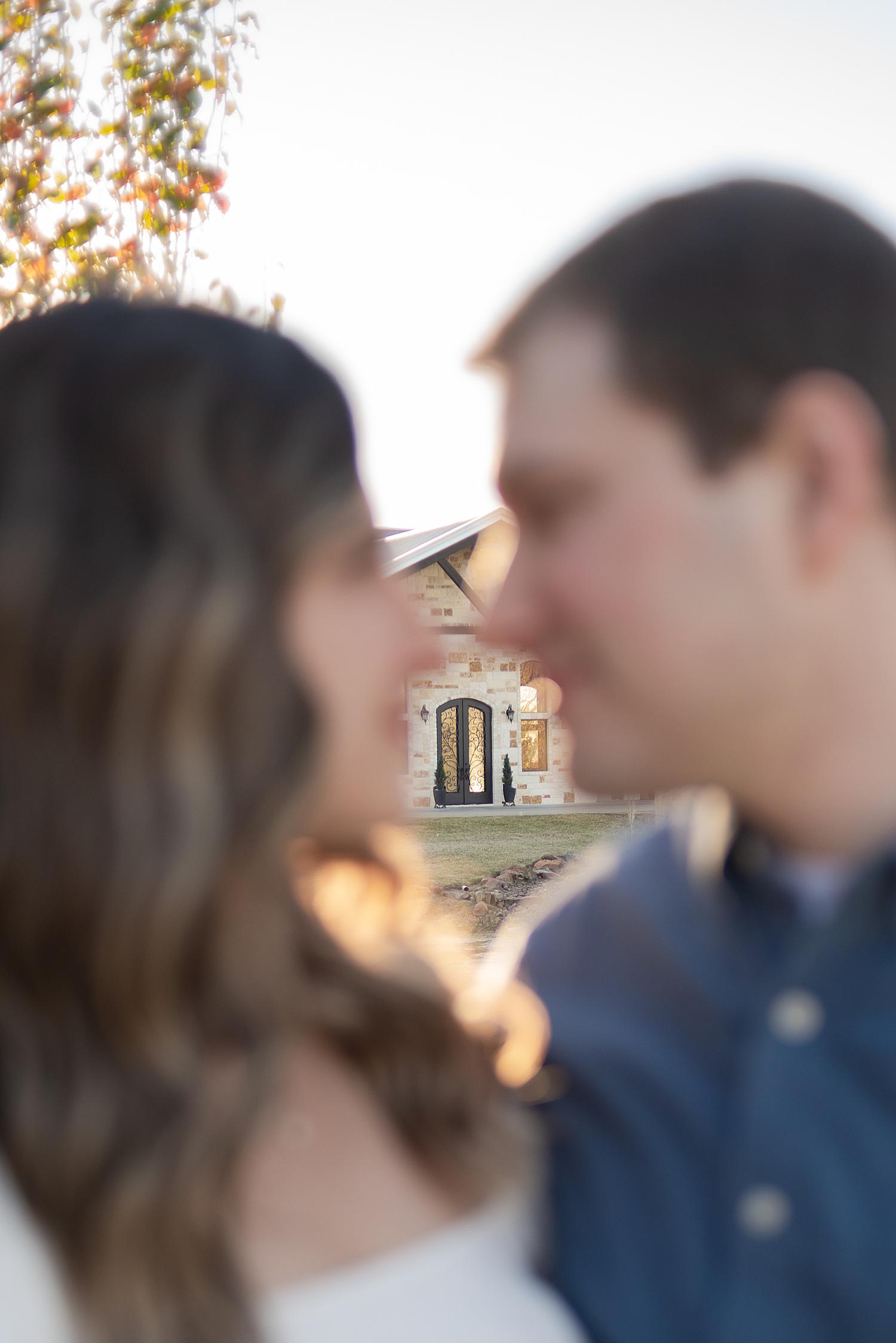 nose to nose photo with a wedding venue in focus in the back
