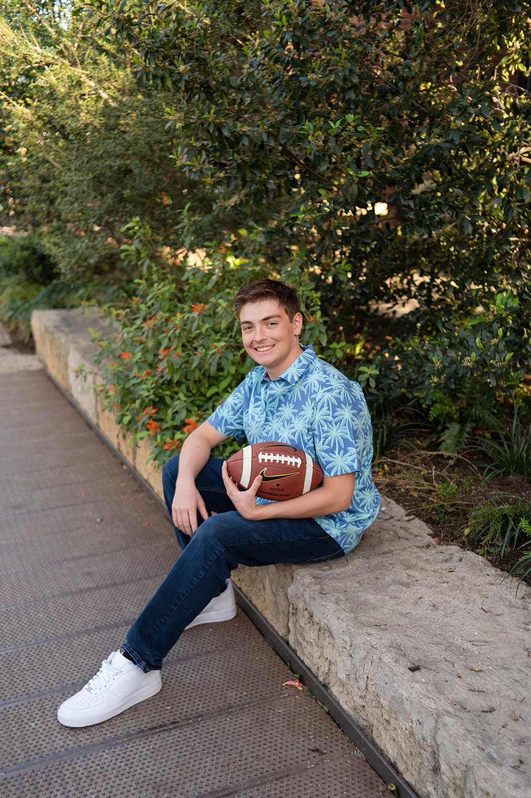 Senior at the Pearl District sitting and holding a football
