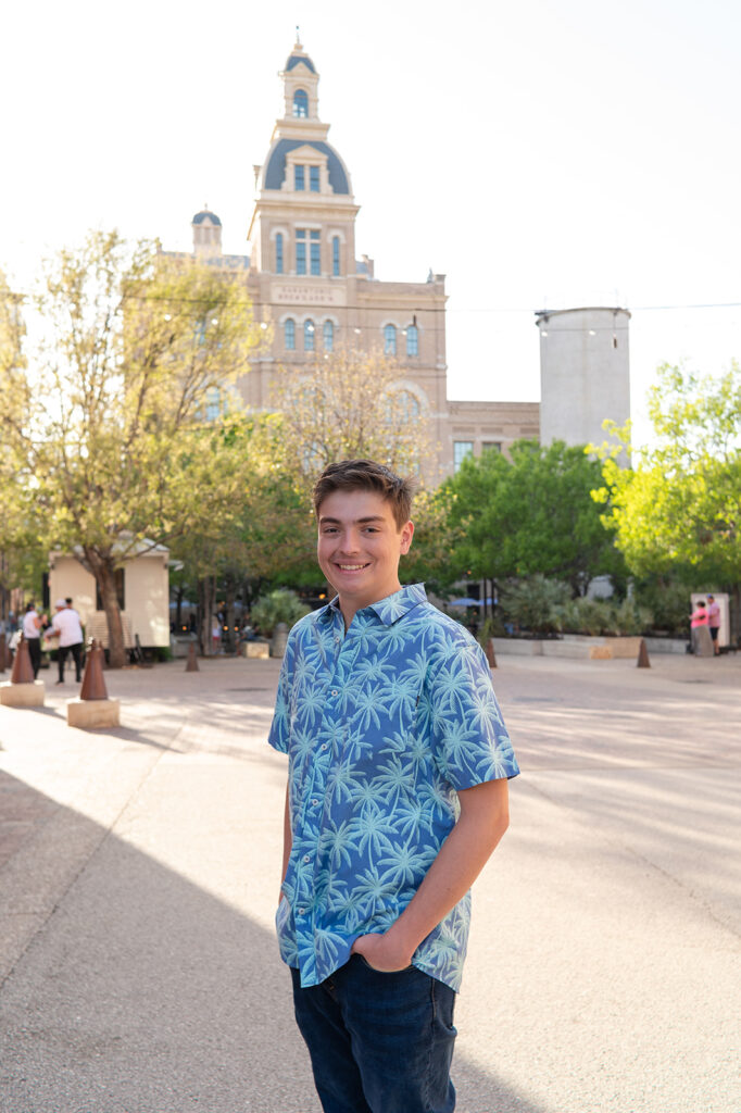 Senior guy in a blue hawaiian shirt standing in front of the Pearl Brewery building in San Antonio.