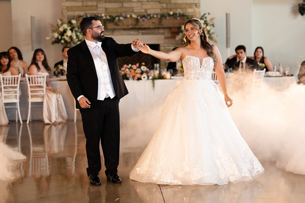 Couple's First Dance at Canyonwood Ridge with head table behind them.